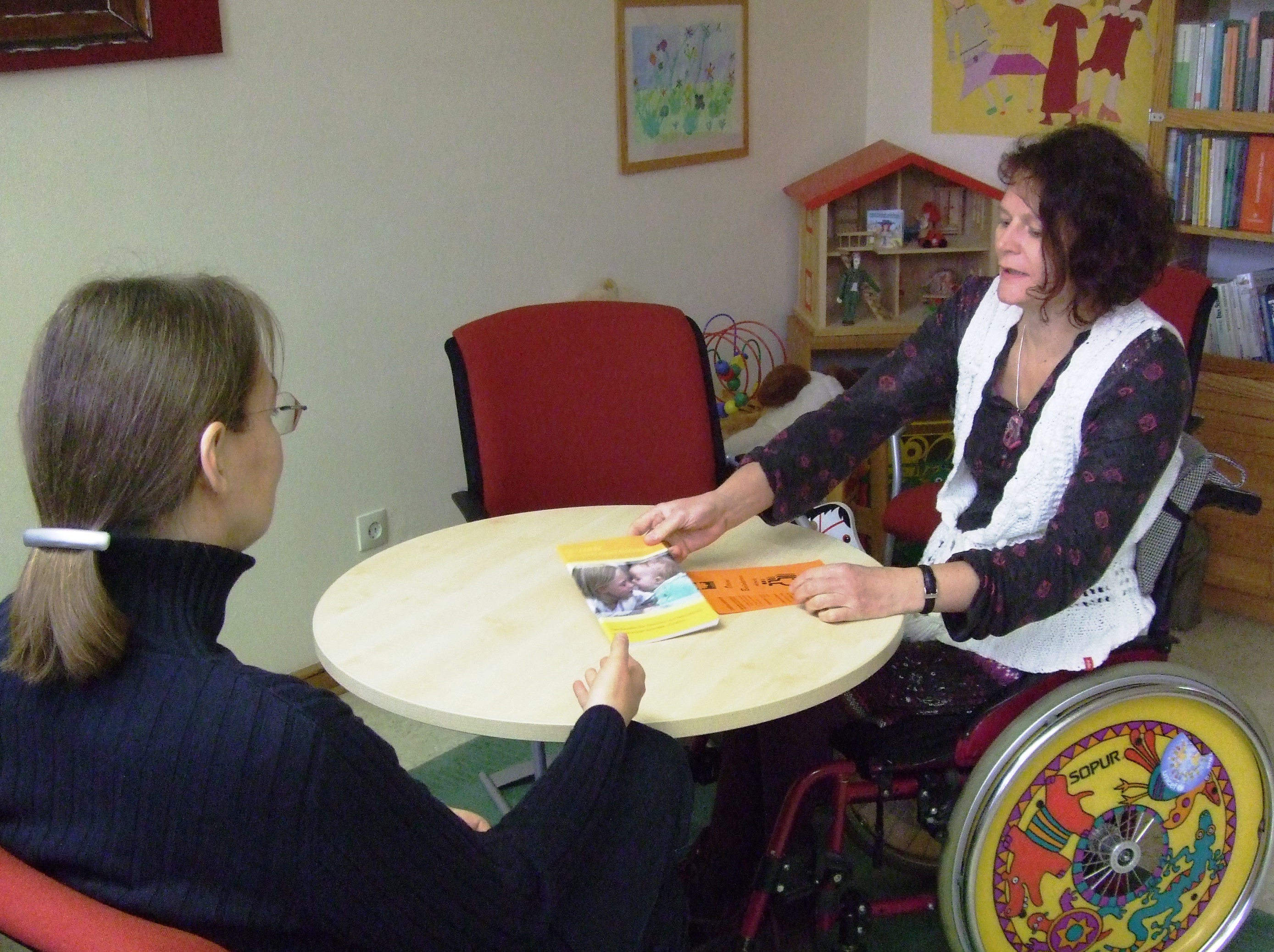 Beraterin erklärt Ratsuchender das Angebot der Schwangerschaftsberatung